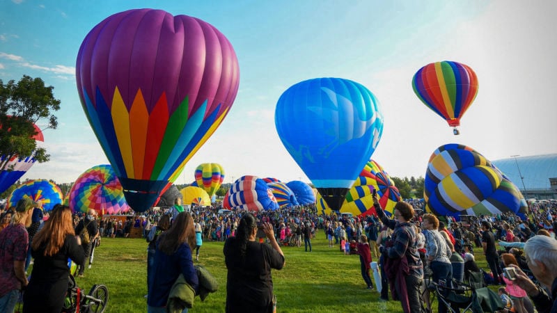 Hot air balloons surrounded by people taking pictures