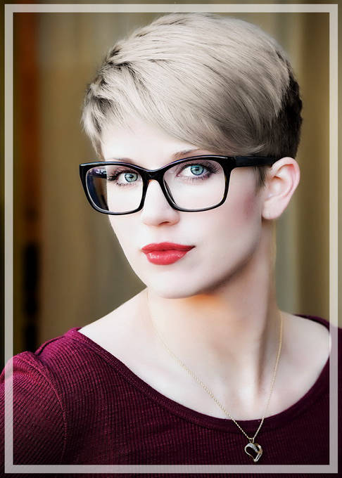 Headshot of short haired blonde with glasses
