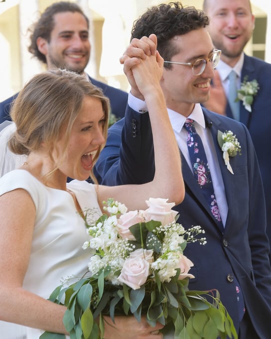 Bride and groom celebrating walk down the isle after wedding